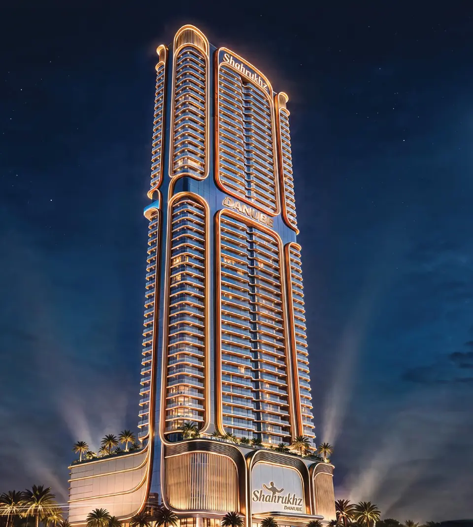 Shahrukhz Residences tower lit up at night, with the Danube name on its crown