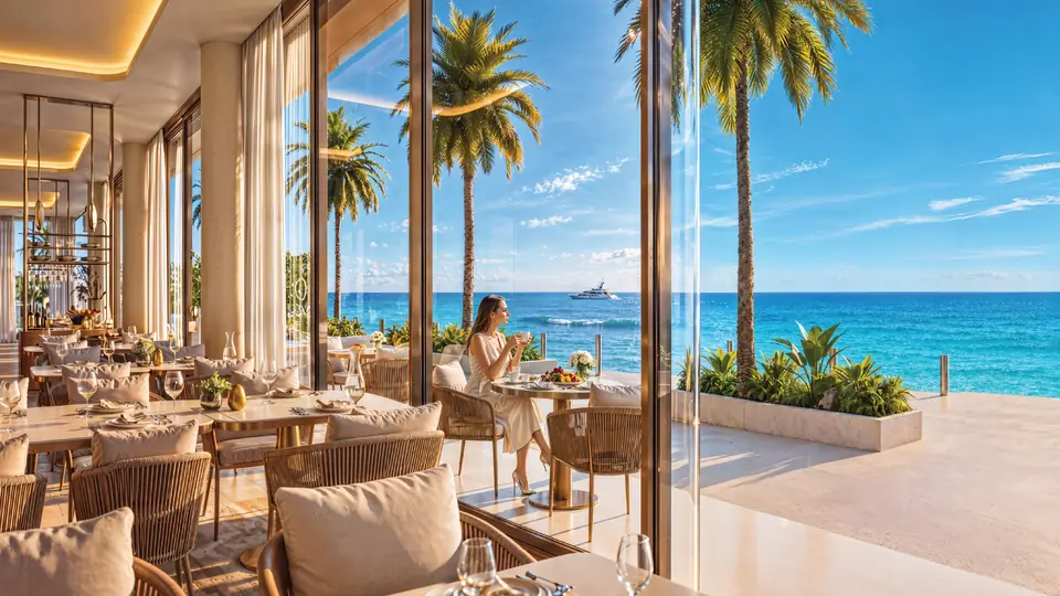 A restaurant terrace opening onto the sea, with a yacht on the horizon